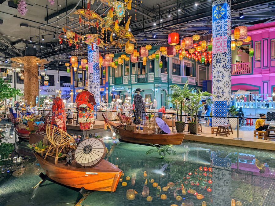 Wooden boats and hanging lanterns in the SookSiam indoor floating market